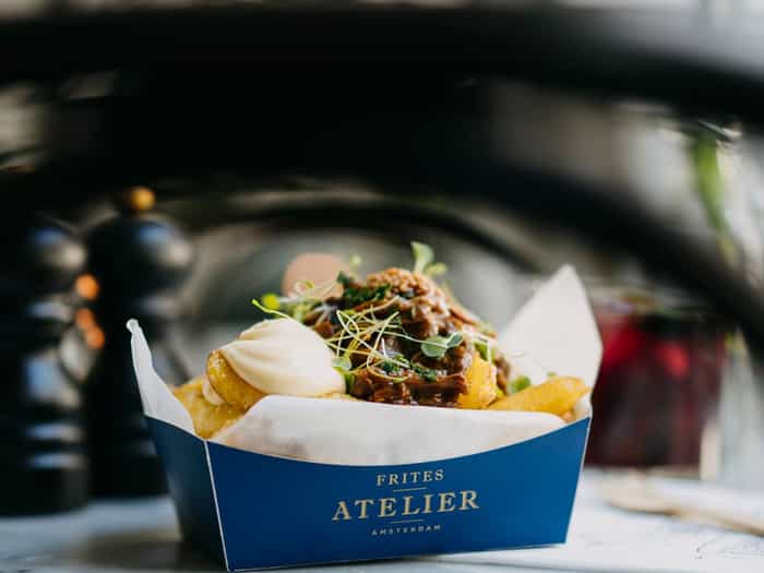 Image of fries in a box, covered by a sauce