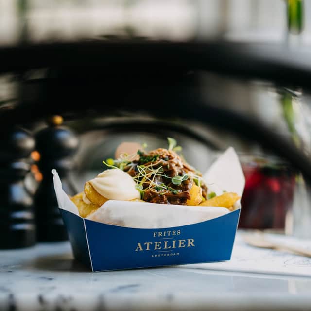 Image of fries in a box, covered by a sauce