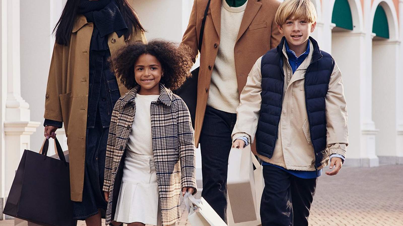 A happy family walking with shopping bags and their dog